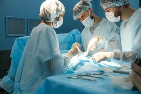 An international team of doctors performs a complex surgical operation on a Stock Photos