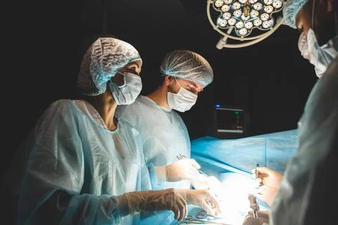 An international team of doctors performs a complex surgical operation on a Stock Photos