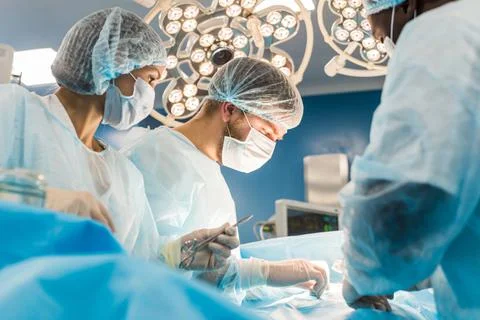 An international team of doctors performs a complex surgical operation on a Stock Photos