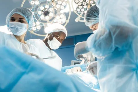An international team of doctors performs a complex surgical operation on a Stock Photos