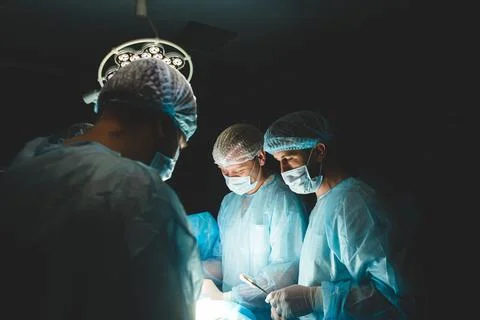 An international team of doctors performs a complex surgical operation on a Stock Photos