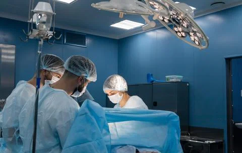 An international team of doctors performs a complex surgical operation on a Stock Photos