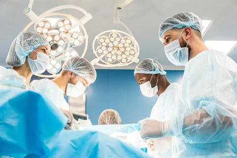 An international team of doctors performs a complex surgical operation on a Stock Photos