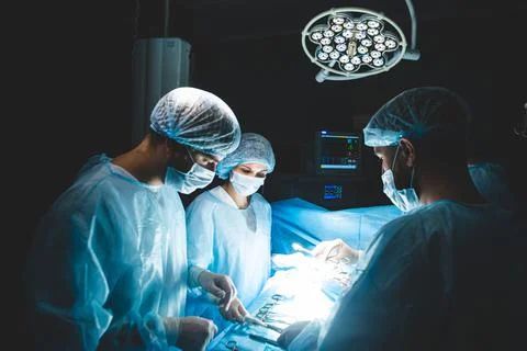 An international team of doctors performs a complex surgical operation on a Stock Photos
