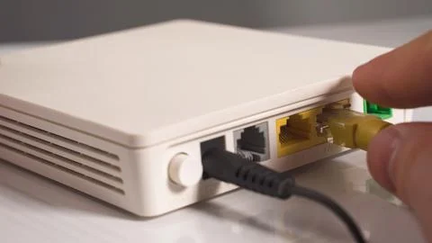 Internet cable in the hand inserting in the socket router Stock Photos