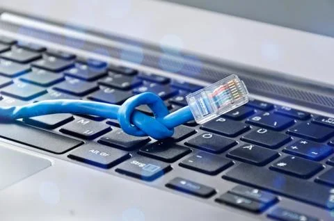 Internet cable with knot on computer keyboard symbolising bandwidth problems Stock Photos