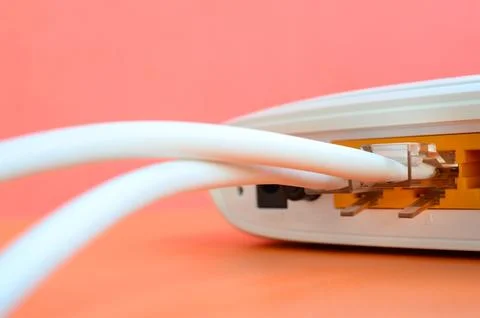 The Internet cable plugs are connected to the Internet router, which lies o.. Stock Photos