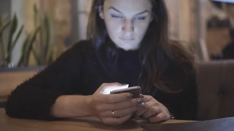 Internet, communication and technology concept - woman with cell phone in cafe Video stock 88398587