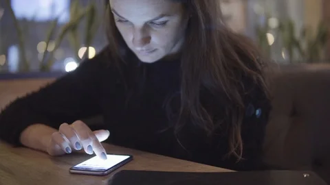 Internet, communication and technology concept - woman with cell phone in cafe Video stock 88398629