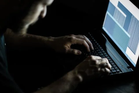 Internet crime concept. Hacker working on a code on dark digital background w Фото