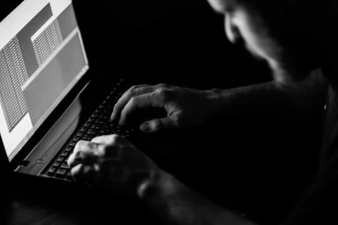 Internet crime concept. Hacker working on a code on dark digital background w 库存照片