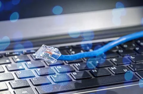 Internet LAN cable on computer keyboard symbolizing cyberspace and connectivity Stock Photos