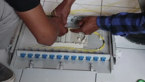 Internet network technicians maintain fiber optic cables in a data center. 動画素材 342909529