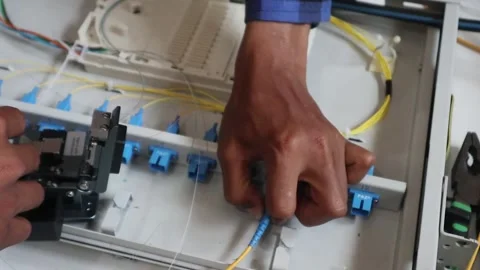 Internet network technicians maintain fiber optic cables in a data center. 動画素材 343328778