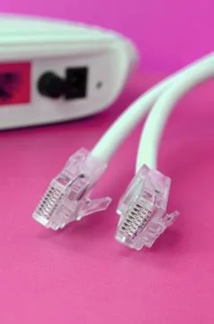 Internet router and Internet cable plugs lie on a bright pink background. Ite Stock Photos