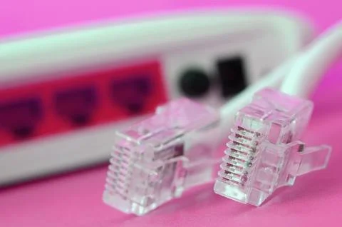 Internet router and Internet cable plugs lie on a bright pink background. I.. Stock Photos