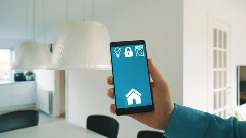 Internet of things app on mobile phone turns on lights in smart home Stock Footage 101831875