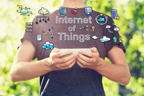 Internet of Things concept with young man holding his smartphone Stock Photos