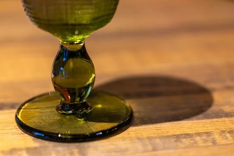 The interplay of light and shadow on the emerald green glass stem and the w.. Stock Photos