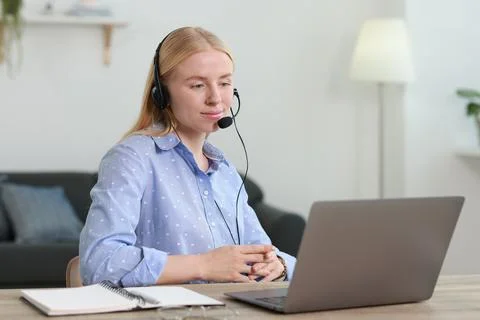 Interpreter in headset working with laptop at table indoors Stock Photos