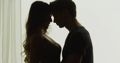 Interracial couple being intimate in front of window Stock-Footage 42688267