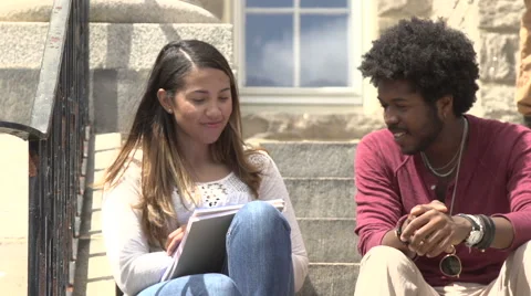 An interracial couple chat on school steps. Stock Footage 44117033