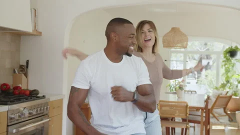 Interracial Couple Having Fun Dancing in Kitchen at Home Видео 270335896