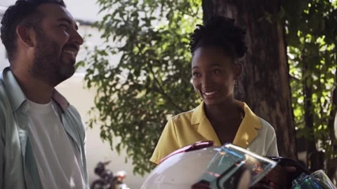 Interracial couple holding motorcycle helmets and smiling Stock Footage 337905676