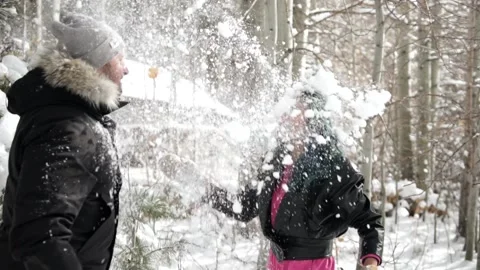 Interracial Couple Throws Snowballs at Faces During First Snow in Forest Stock Footage 146047500