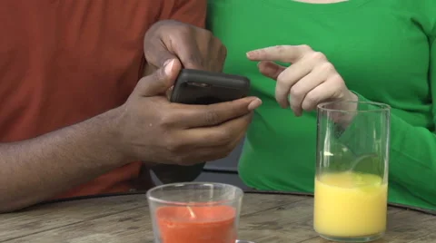 An interracial couple use a cell phone together - close-up Stock Footage 44203346