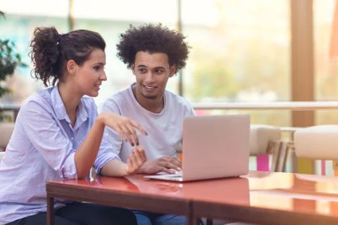 Interracial couple using tablet computer in coffee shop Stock Photos