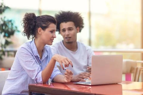 Interracial couple using tablet computer in coffee shop 写真素材