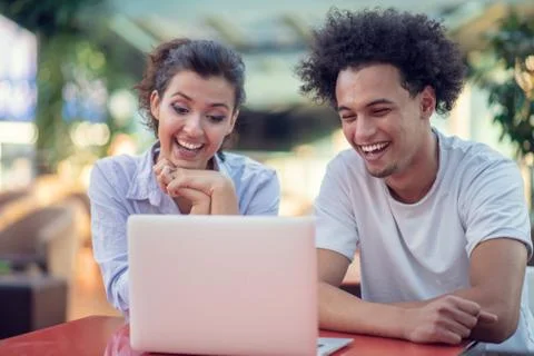 Interracial couple using tablet computer in coffee shop Stock Photos
