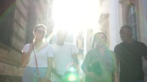 Interracial group of students walking around the city. Sunny portrait of four Stock Footage 134468662
