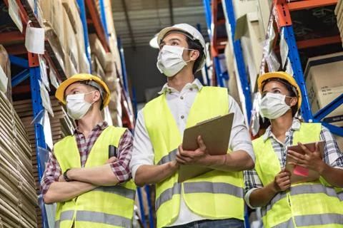 Interracial warehouse worker team with face mask 库存照片