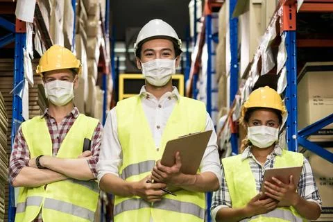 Interracial warehouse worker team with face mask Portrait of Interracial g... 库存照片