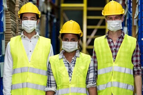Interracial warehouse worker team with face mask Portrait of Interracial g... Stockfoto's