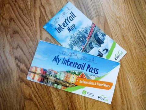 An Interrail pass and a folded Interrail map of Europe lying on a wooden floor Stock Photos