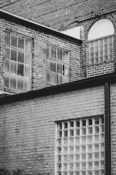 Intersecting brick walls and windows from older indutrial facility Stock Photos