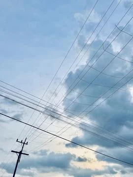 Intersecting Power Lines Against a Cloudy Sky Stock Photos
