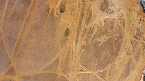 Intersecting tire loops on ochre desert plain — top-down drone Stock Footage 315157912