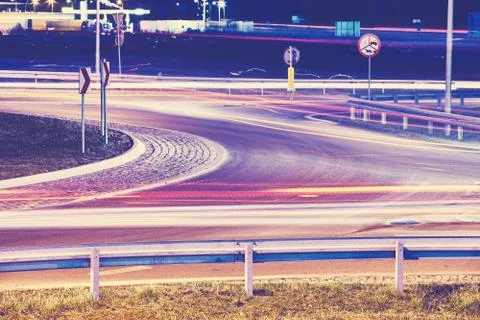 Intersection with car light trails at night. Stock Photos