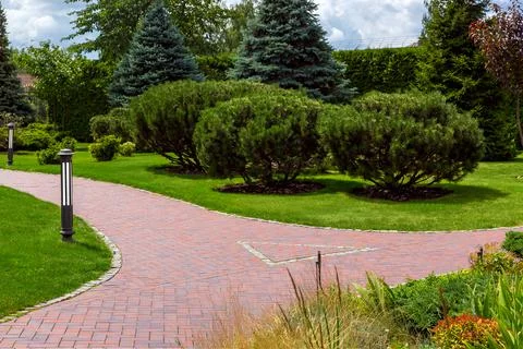 The intersection of footpaths from paving slabs for walks in the park. Stock Photos
