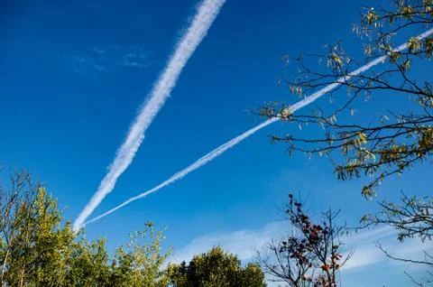 The intersection of the trail from the planes in the bright blue sky. Stock Photos