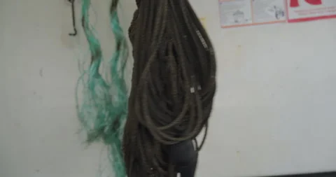 Intertwined ropes form complex knot against white wall Stock Footage 320042669