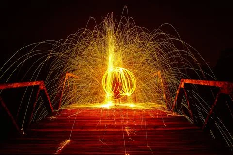 An intertwining circle of yellow light and sparks around a person at night on a 库存照片