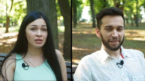 Interview with beautiful young people in the park for a blog with microphones Stock Footage 203914933