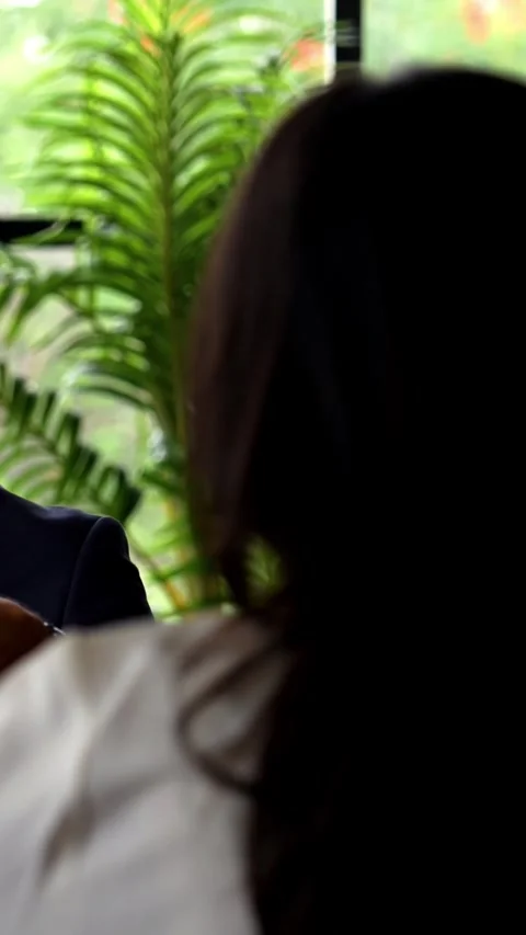 Interviewing female candidate across table, Indian businessman evaluates Stock Footage 342559759