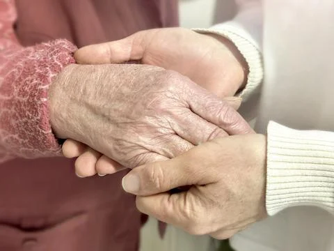 Interweaving of generations: hands of young and old people close-up. Gentle t Stock Photos