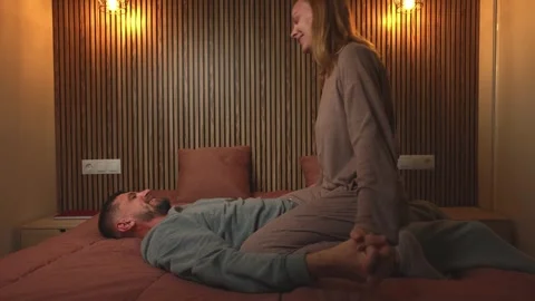 Intimate bedroom scene featuring loving couple in soft pajamas, sharing ten.. Stock Footage 303997065